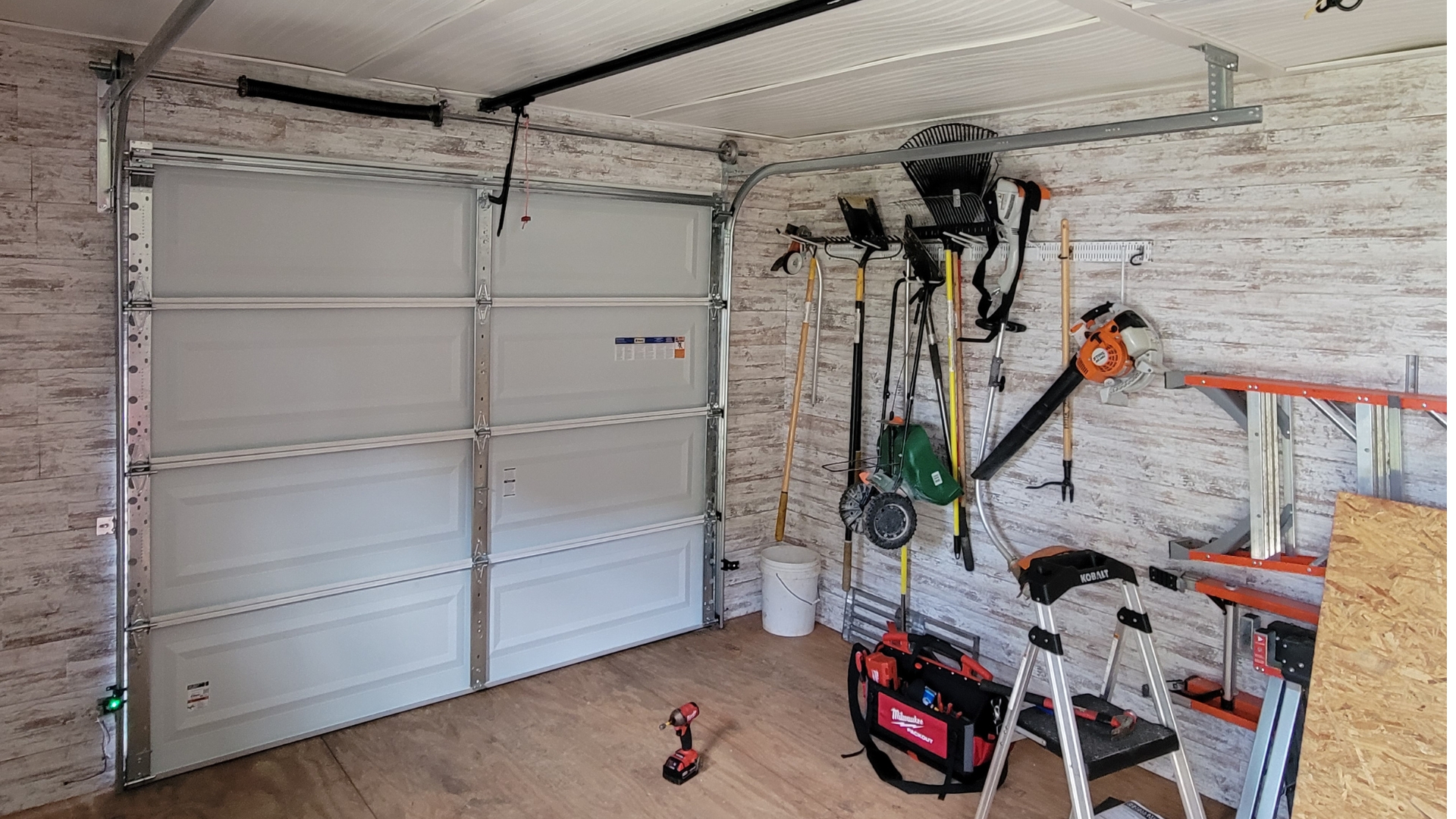 Garage door repair company completes the installation of a new white sectional door