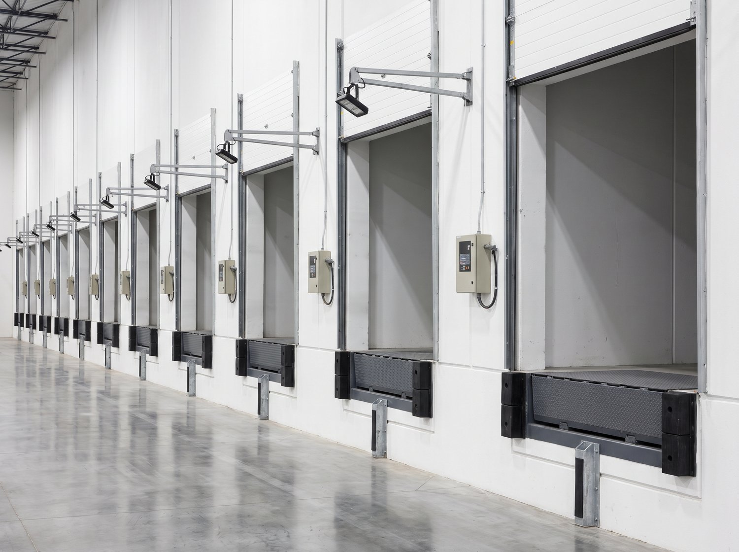 Row of loading dock bays with edge-of-dock levelers and controls serviced in Houston